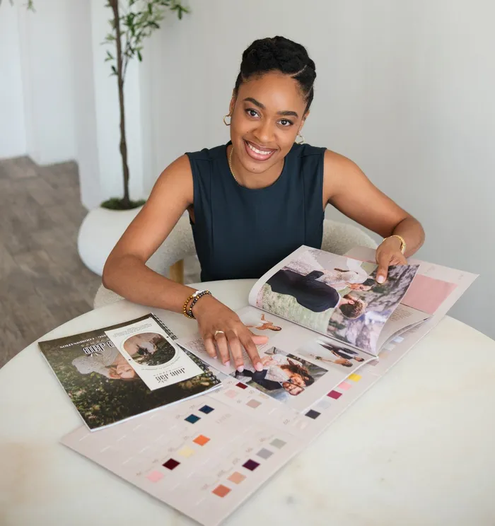 Jheanelle Bishop reviewing a wedding design book and color swatches