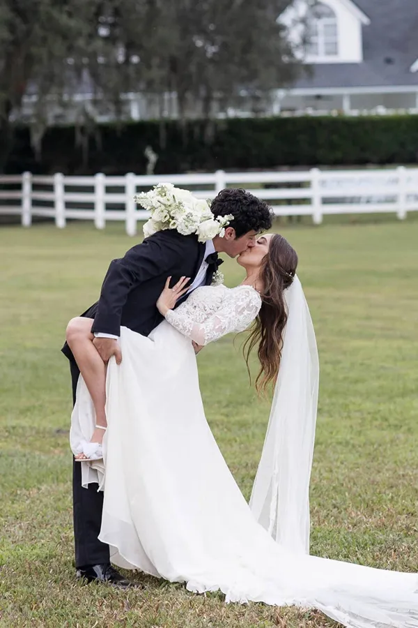 A bride raising her bouquet in celebration