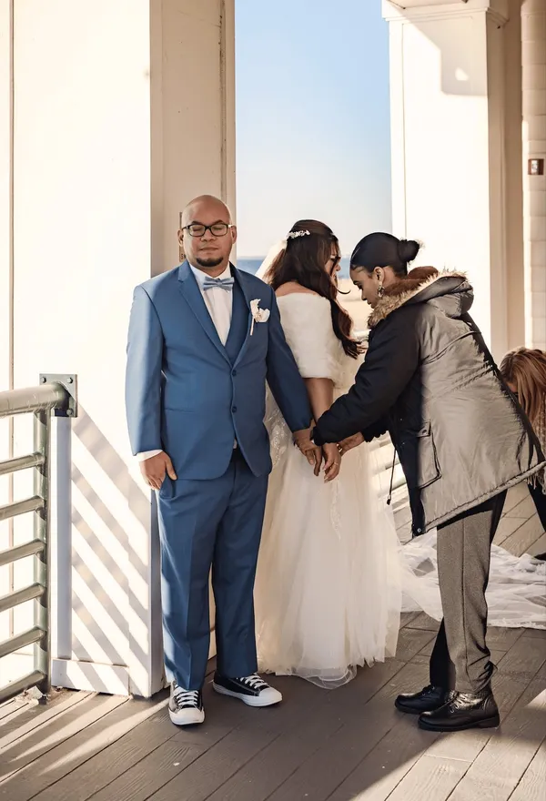 A groom being helped with his jacket before the ceremony